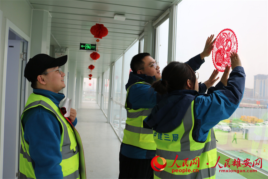 建設者們正在貼窗花。中建三局集團北京有限公司供圖